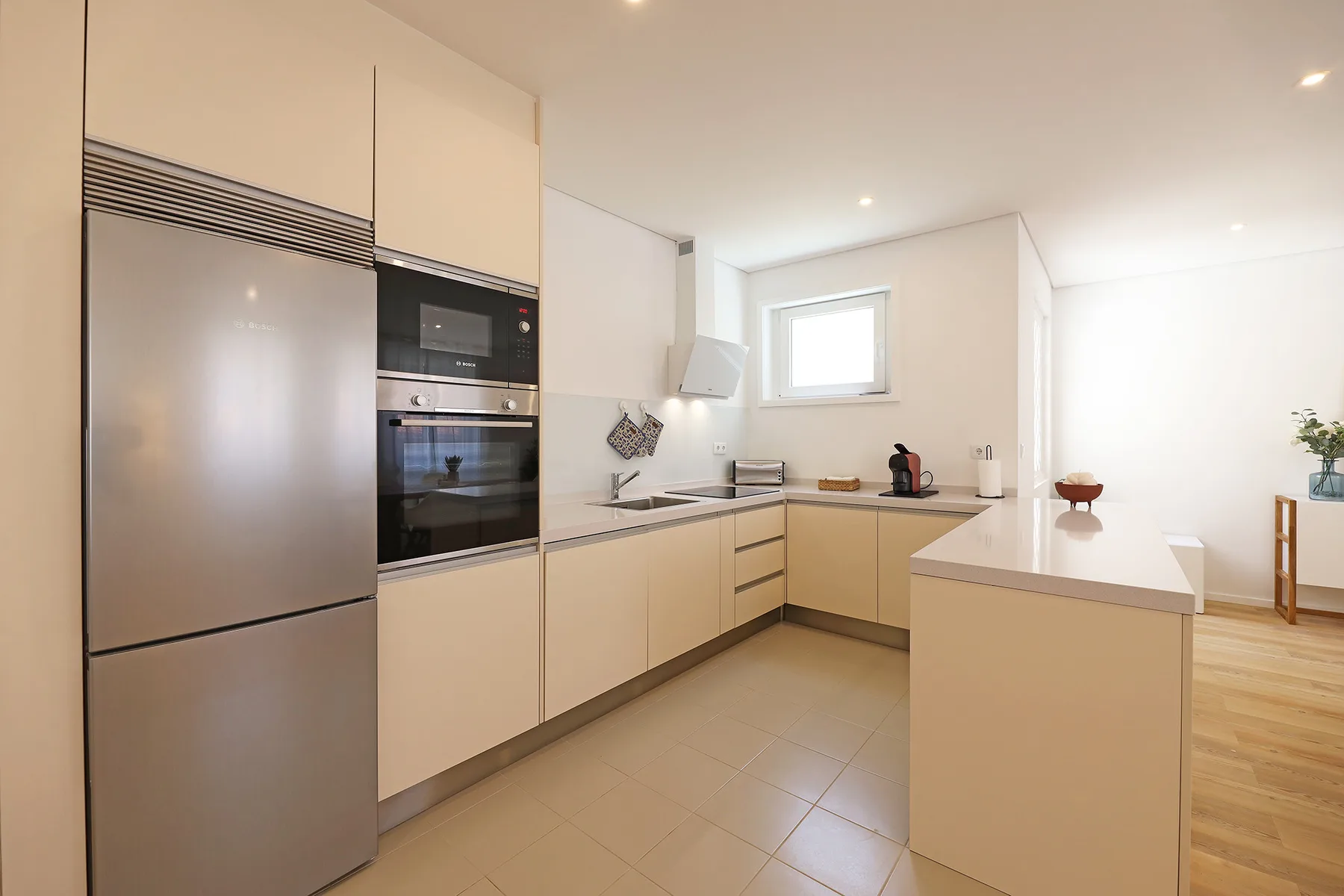 A modern kitchen with pale cabinets and a central island.