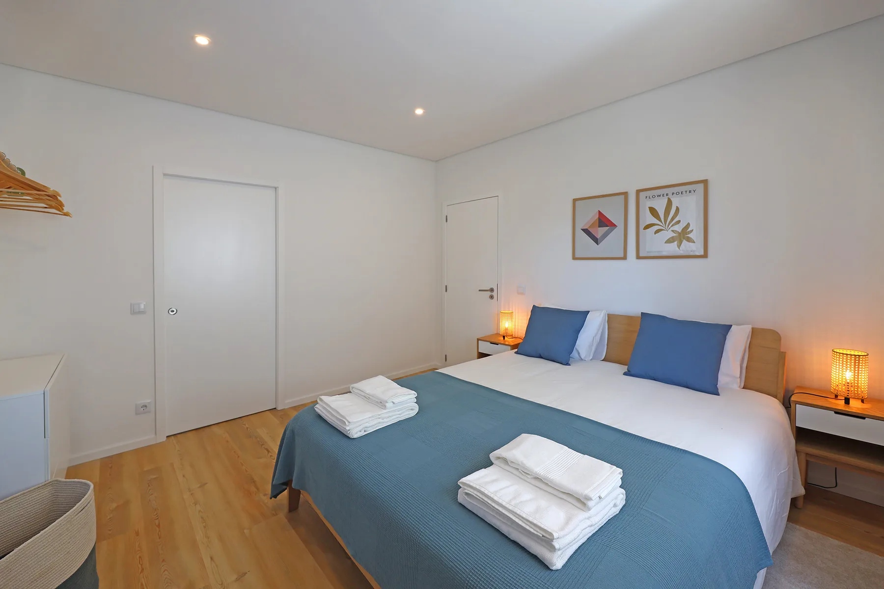 A bedroom with a bed dressed in blue and white linens.