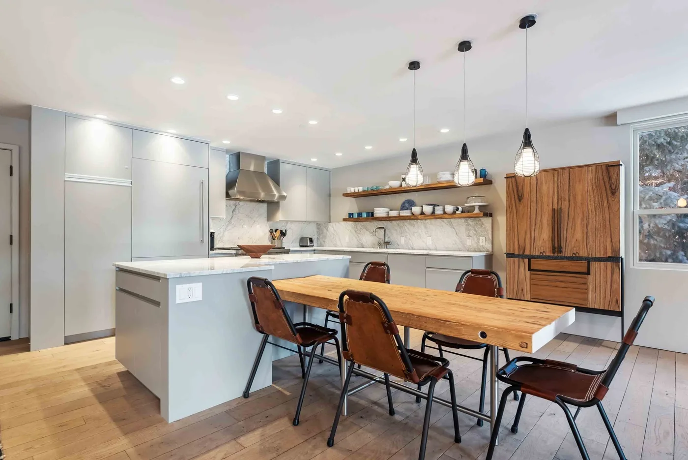 Una cocina moderna con una mesa de comedor de madera y una isla.