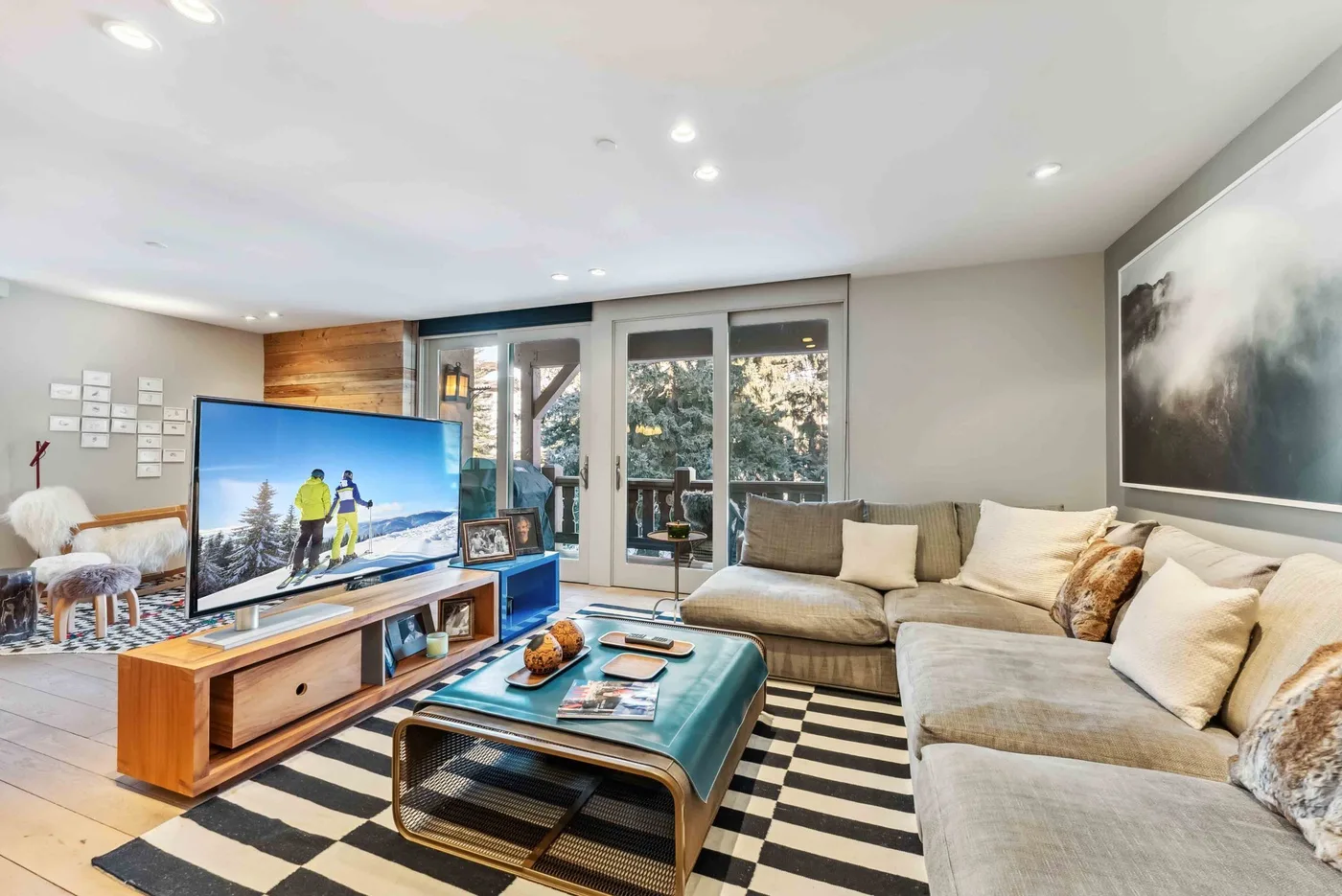 Una sala luminosa con asientos, un televisor y una mesa de centro.