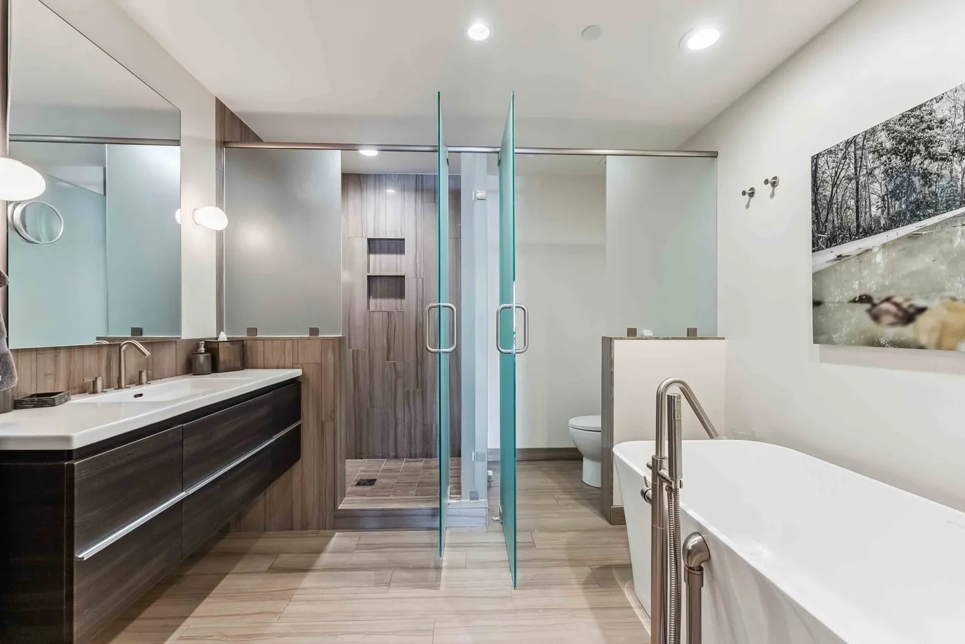 Un baño moderno con tocador de doble lavabo, ducha de vidrio y bañera.