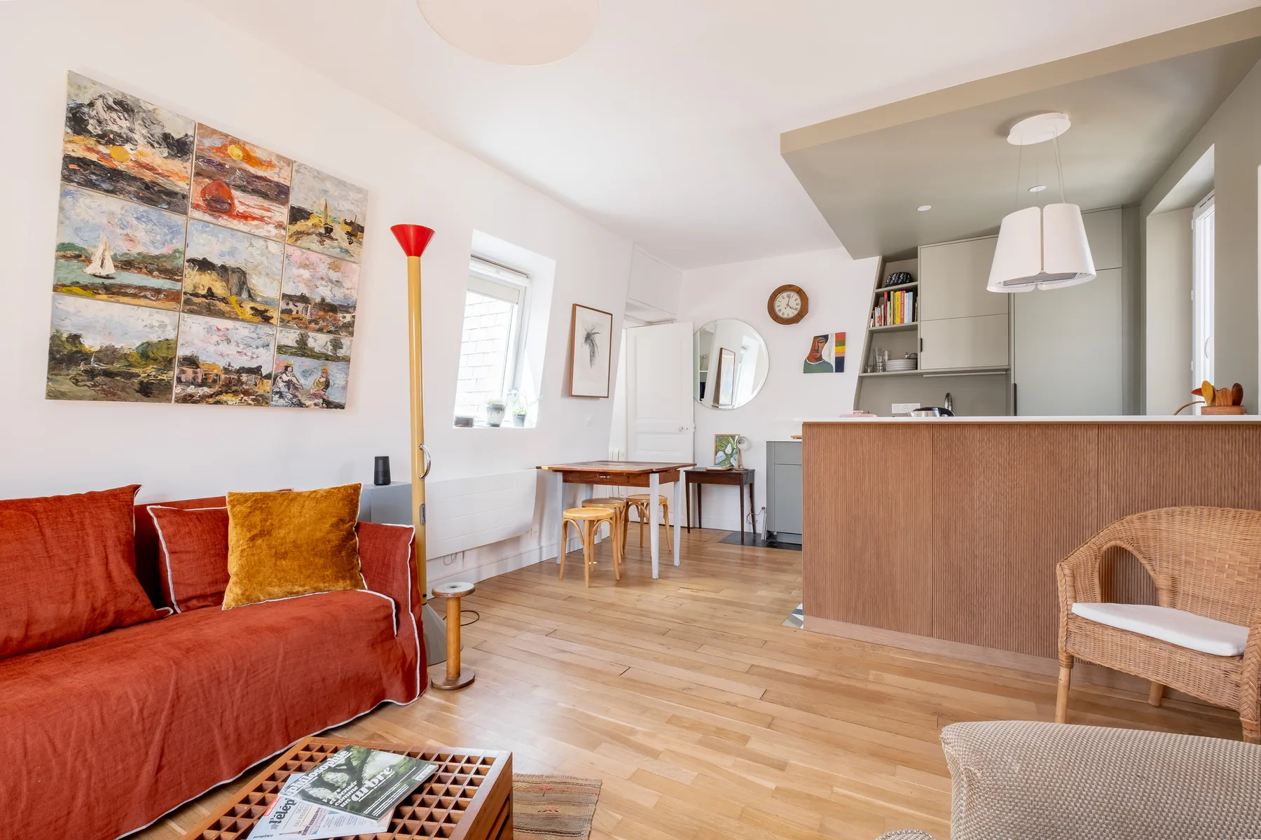 Una luminosa sala de estar y comedor con sofá, mesa y barra de cocina.