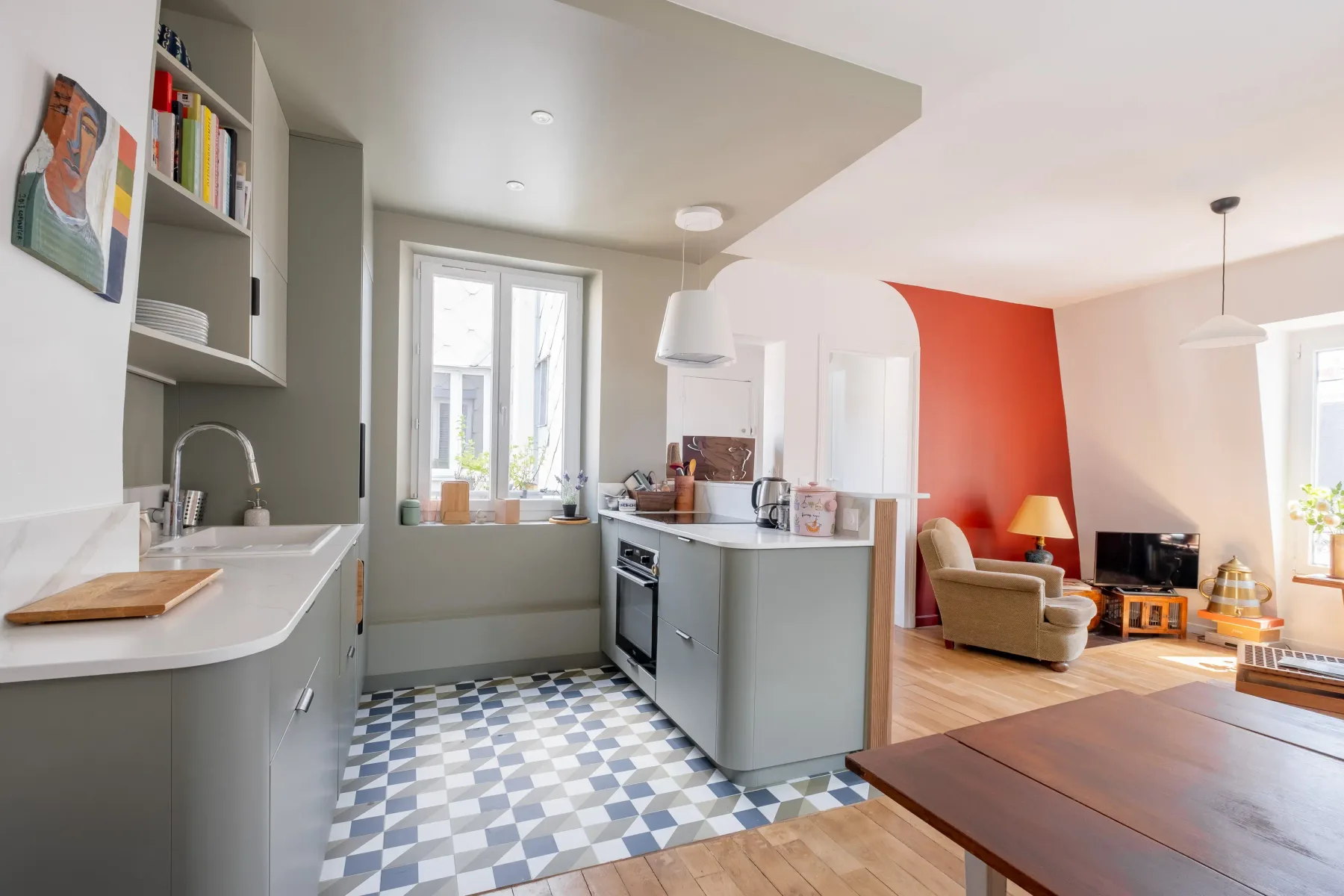 Cocina y sala de estar de concepto abierto con una pared roja llamativa.