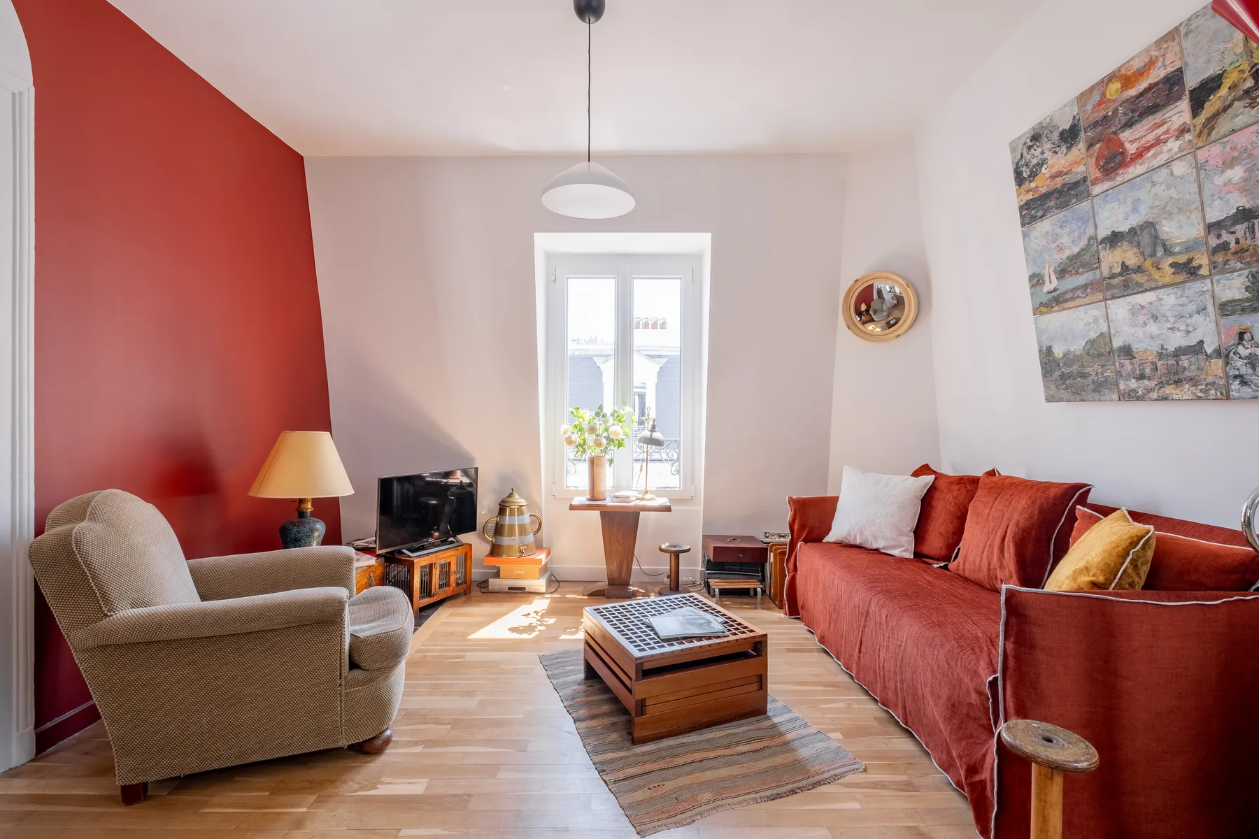 Una sala de estar con asientos alrededor de una mesa de centro y una ventana luminosa.