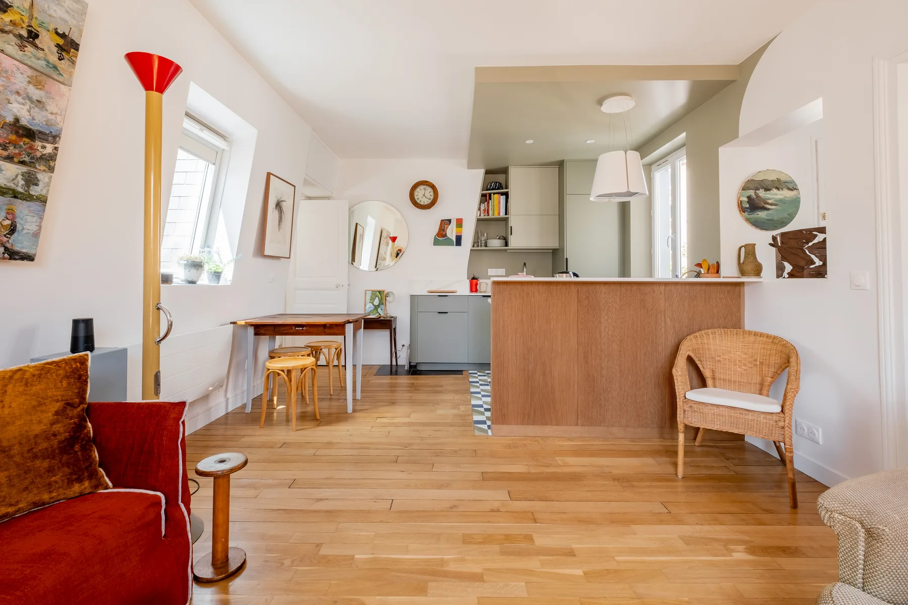 Una sala-comedor abierta con una barra de cocina y suelo de madera.