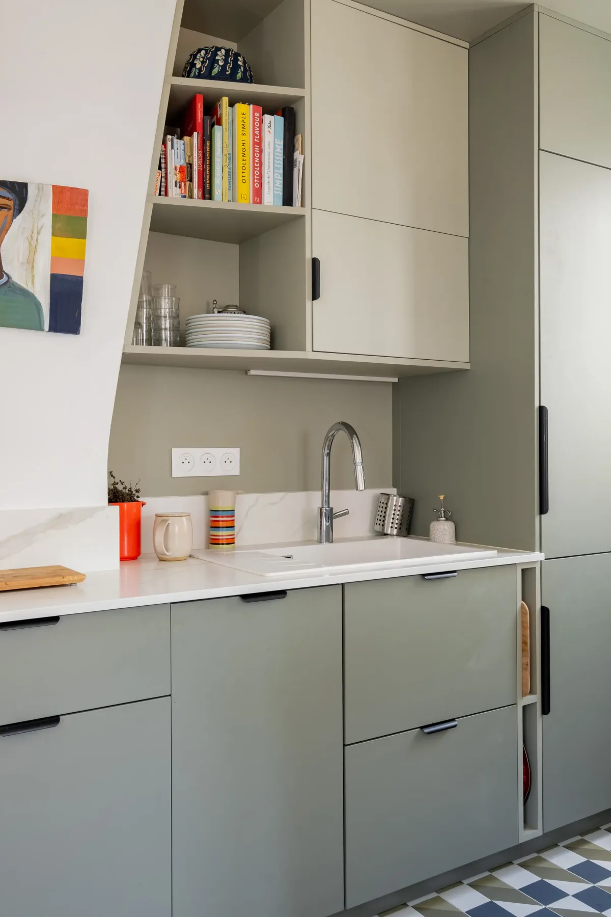 Una cocina compacta con gabinetes claros, una encimera y un fregadero.