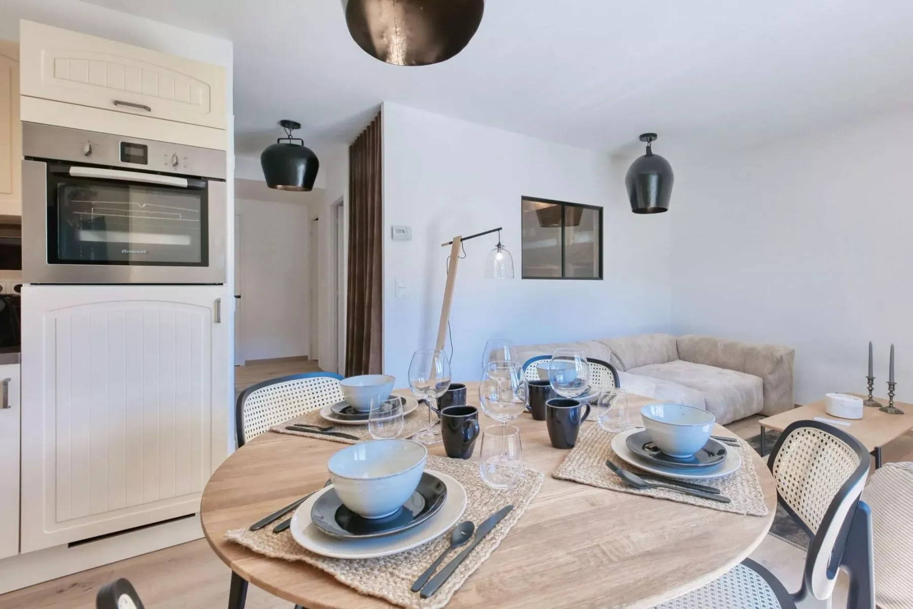 A dining area with a set table and a seating area in the background.