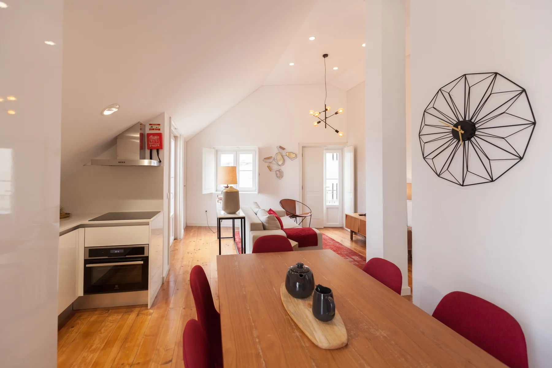 An open-plan living and dining area with a kitchen and a long wooden table.