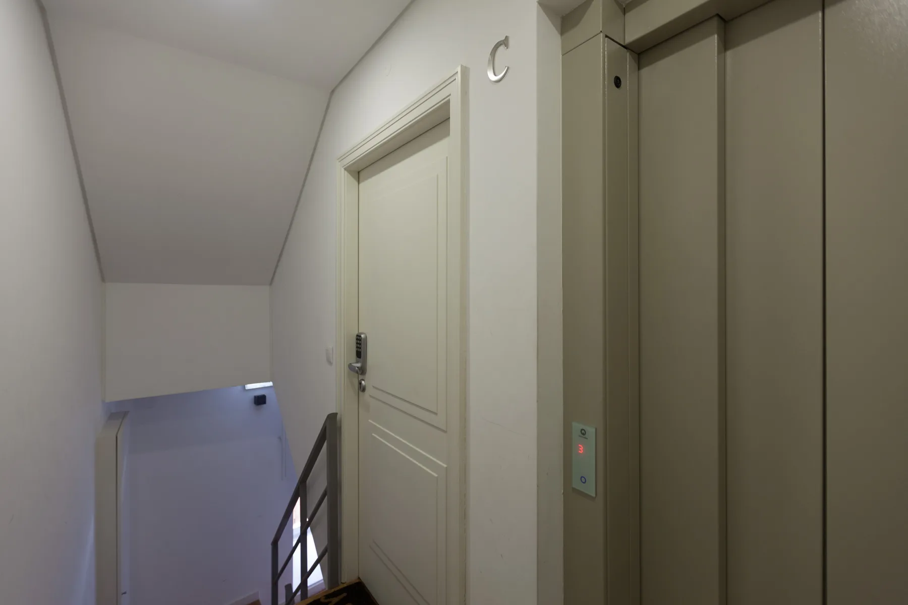 An indoor landing with an elevator and a closed door.