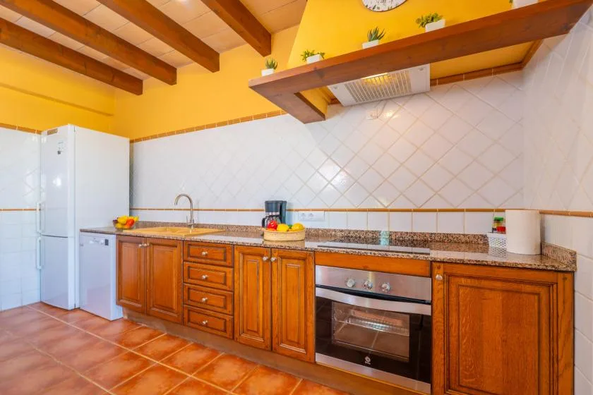 A kitchen with wooden cabinets, a refrigerator, and an oven beneath a tiled backsplash.
