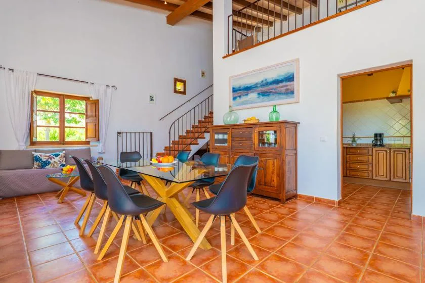 A dining area with a wooden table and chairs beside a staircase.