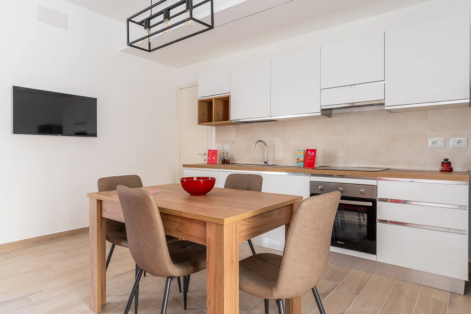 Comedor con una mesa de madera junto a una cocina compacta.