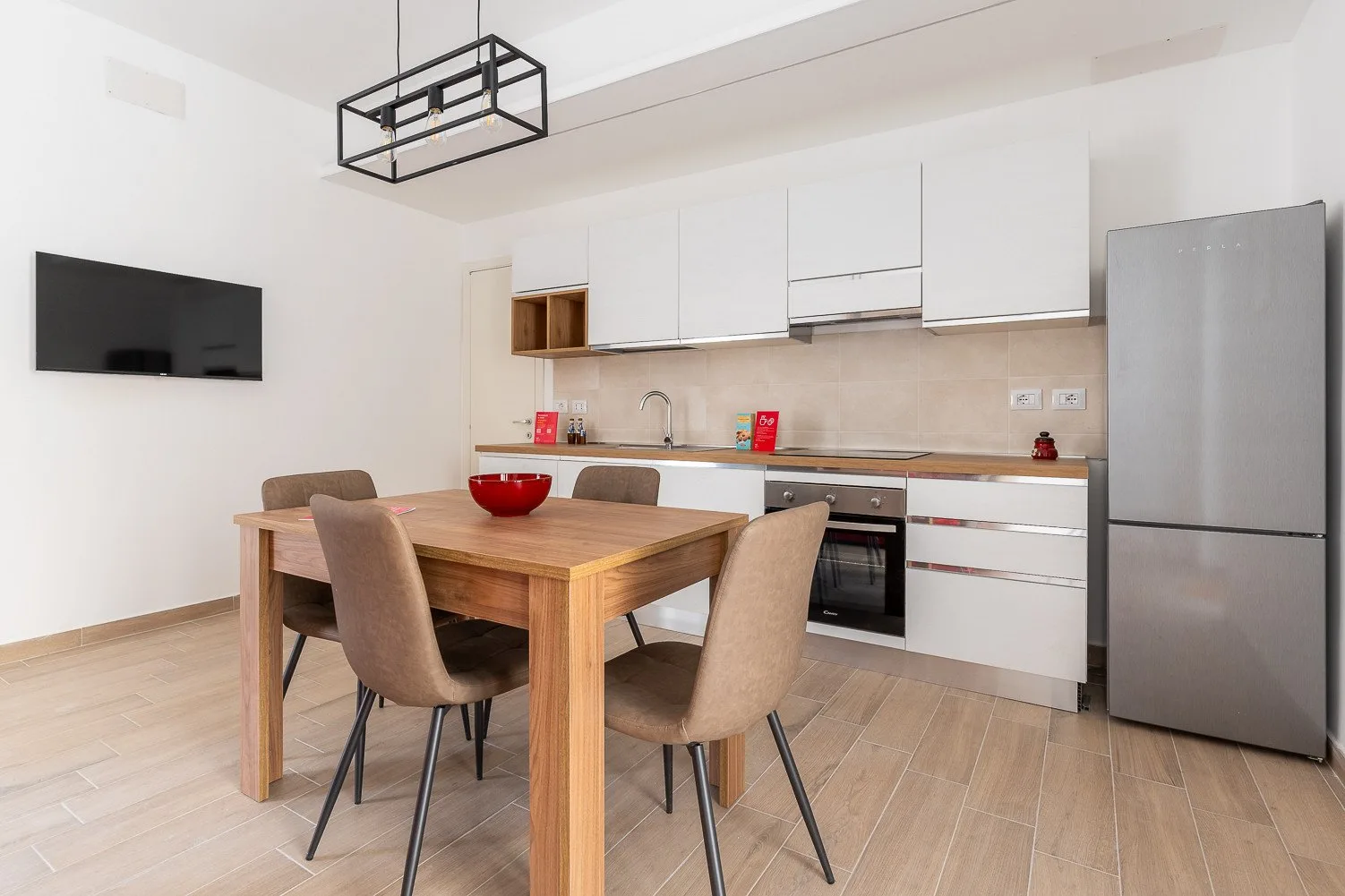 Comedor con una mesa de madera y asientos junto a una cocina.