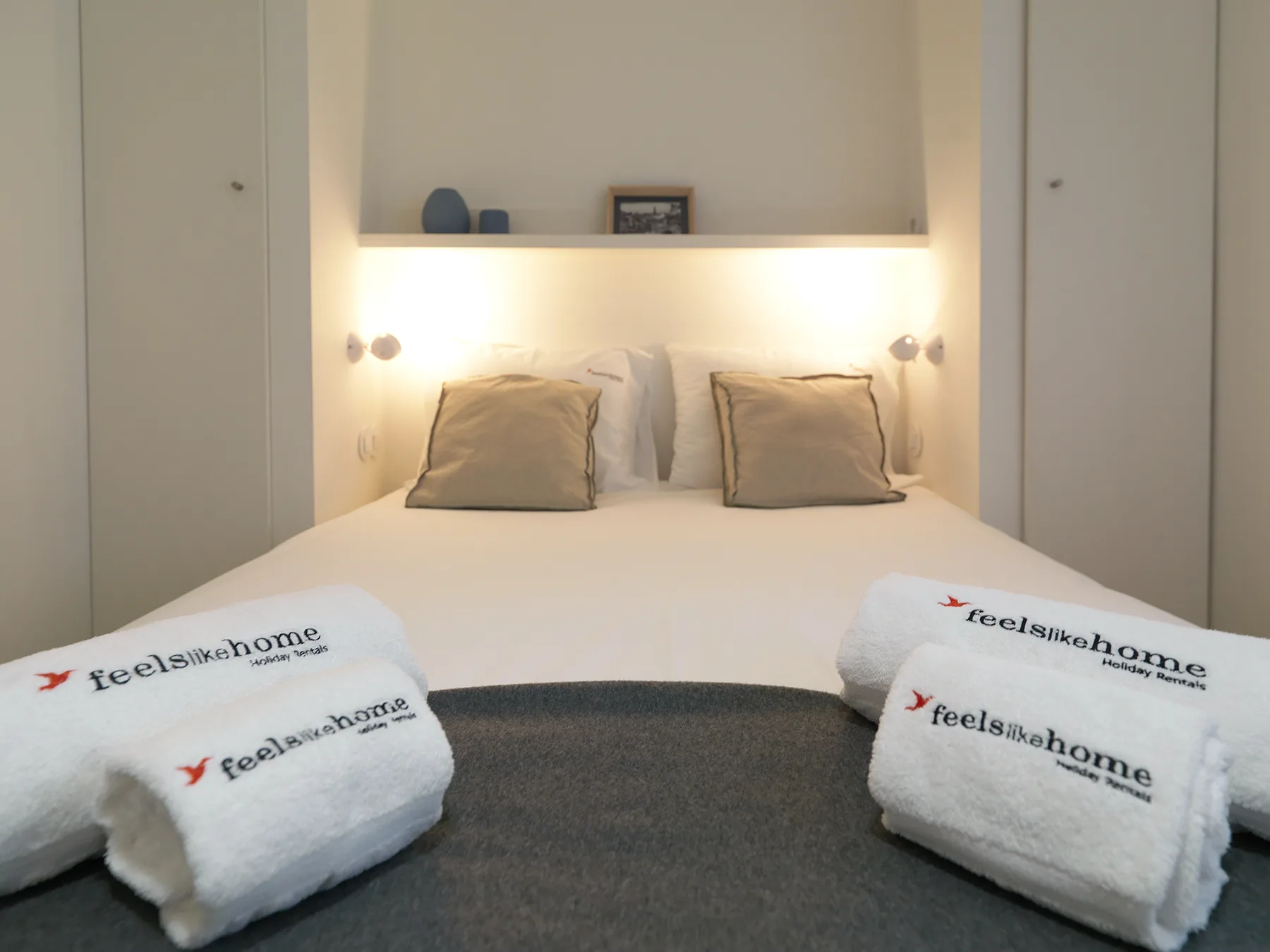 Un dormitorio con una cama bien tendida y toallas dobladas.