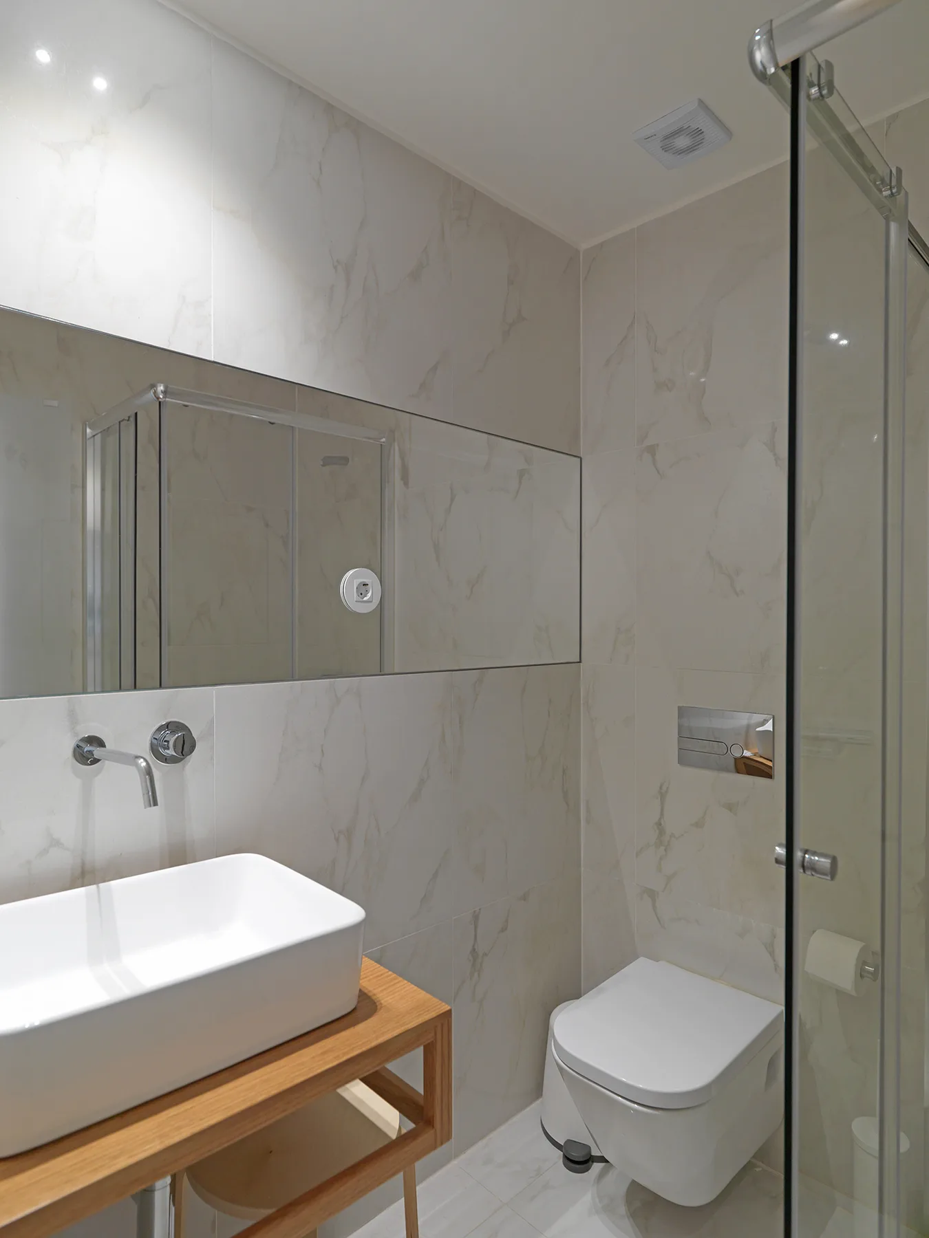 Un baño con lavabo, inodoro y ducha de vidrio.