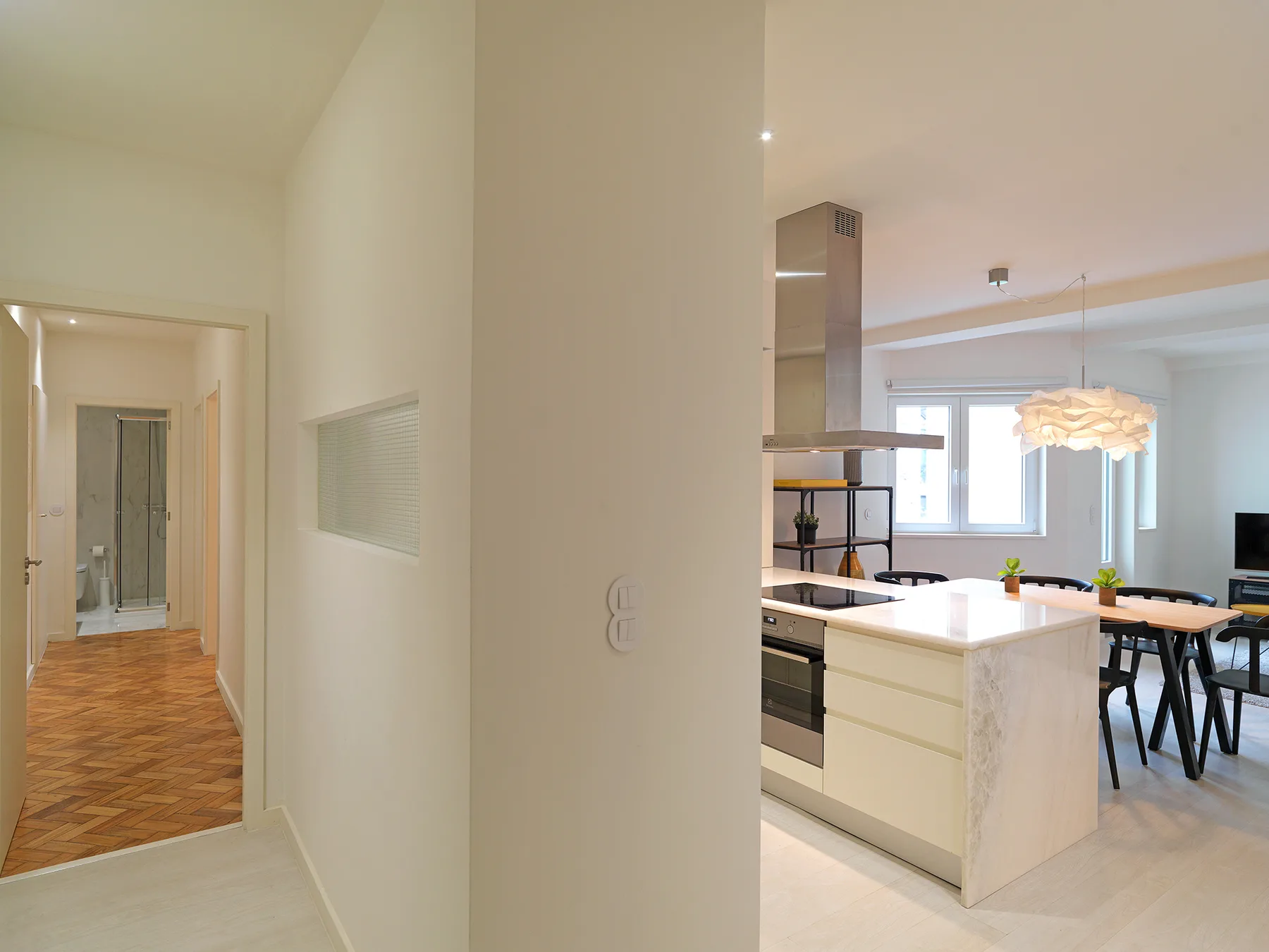 Interior de un apartamento con una isla de cocina y un comedor.