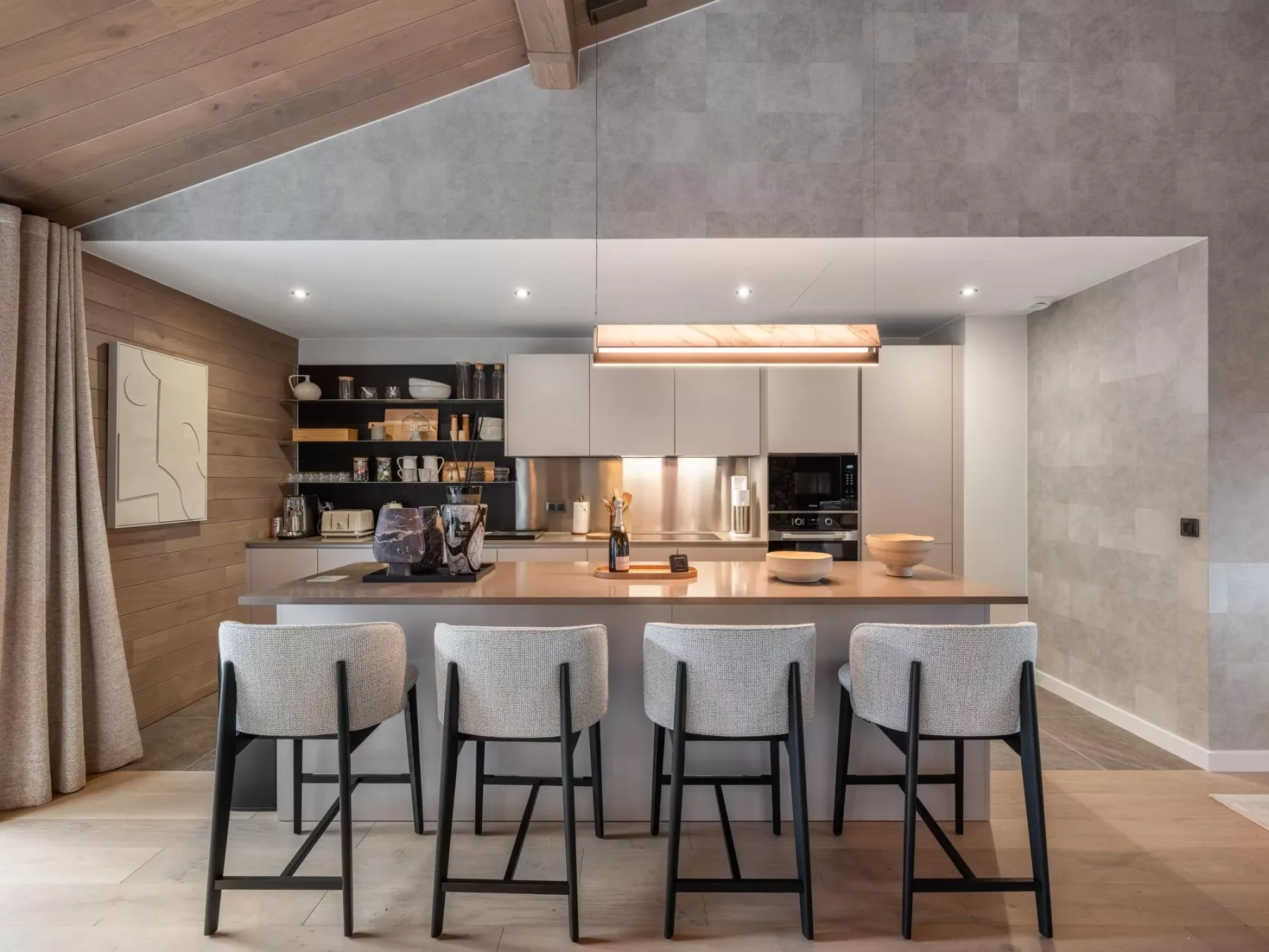 Una cocina moderna con una isla amplia y varios taburetes.