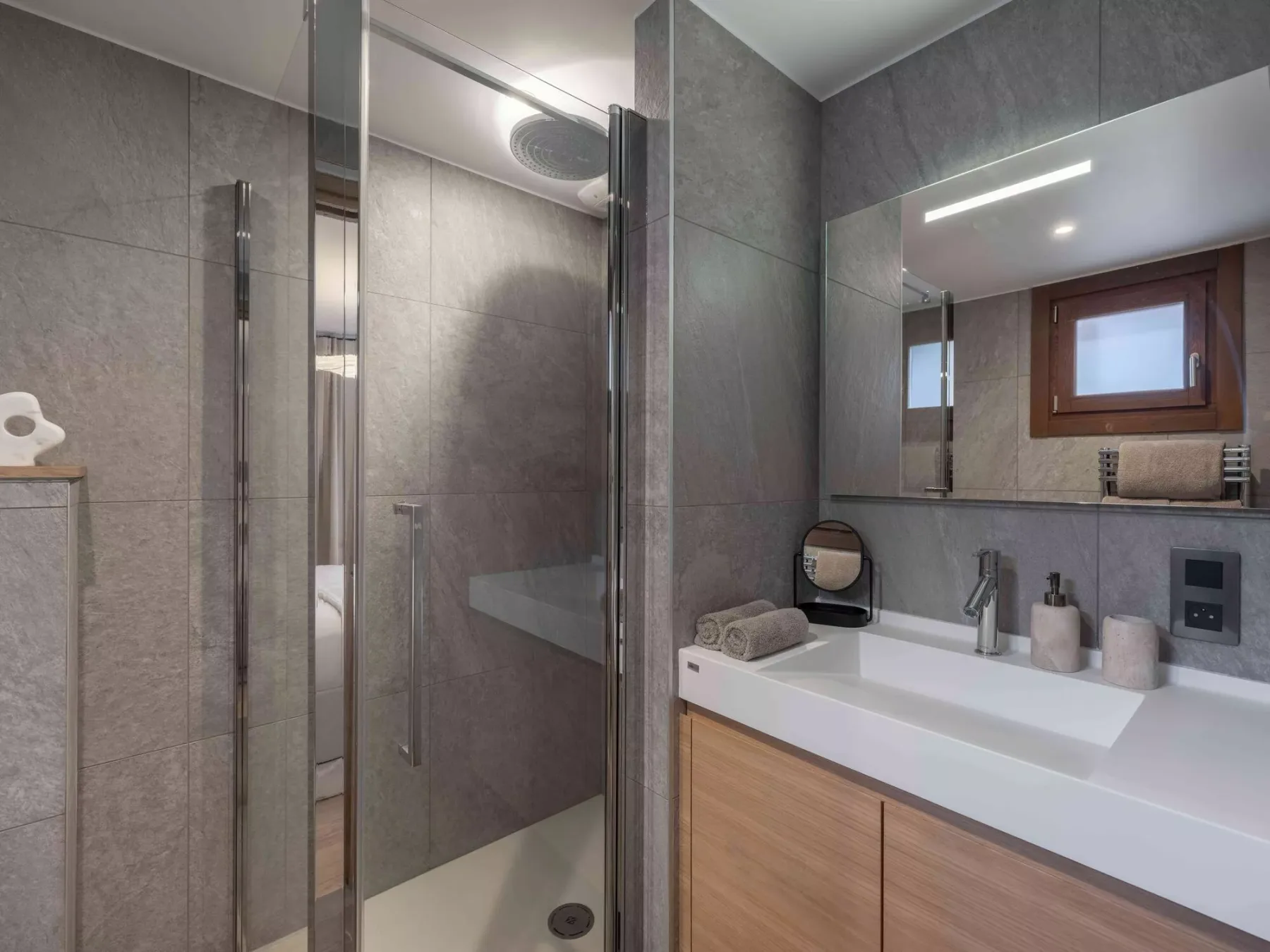 Un baño moderno con ducha de vidrio y un amplio lavabo.