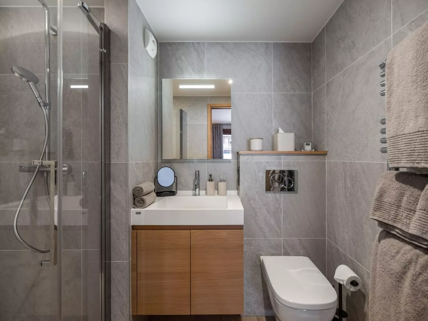 Un baño con ducha de vidrio, lavabo e inodoro.