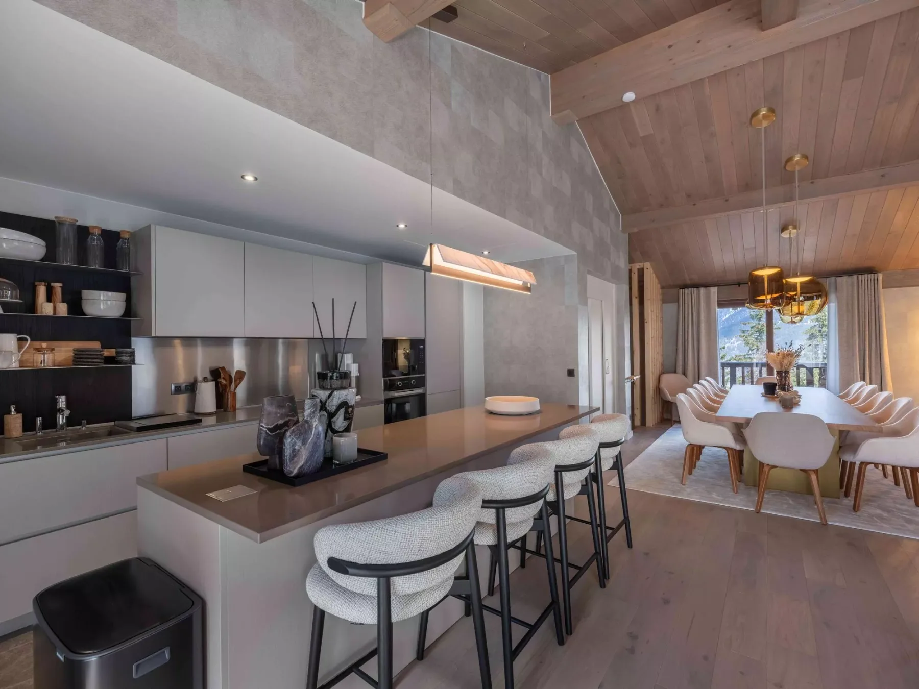 Una cocina abierta al comedor, con una isla y una mesa de comedor.