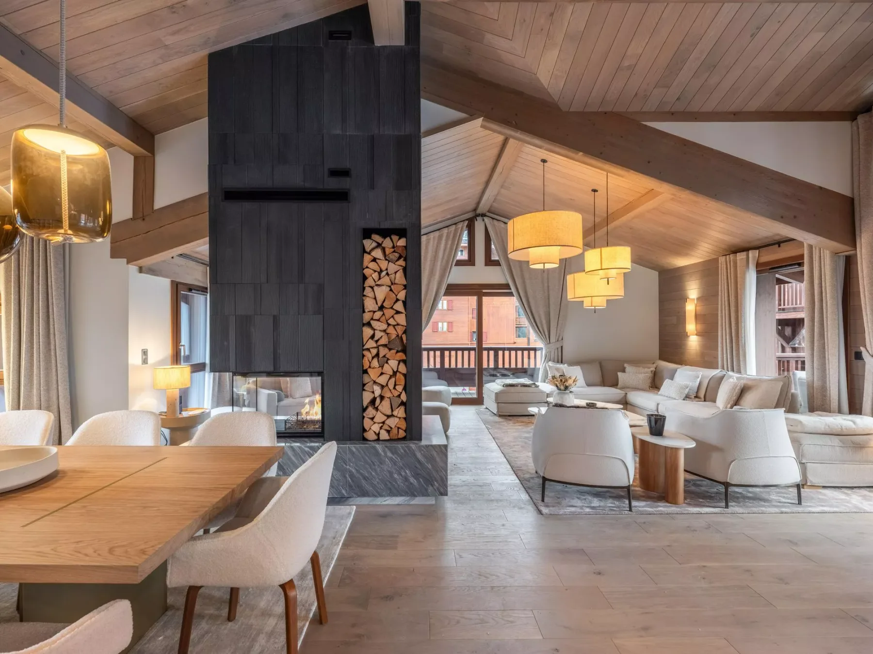 Una amplia sala de estar con mesa de comedor, zona de asientos y techo revestido de madera.