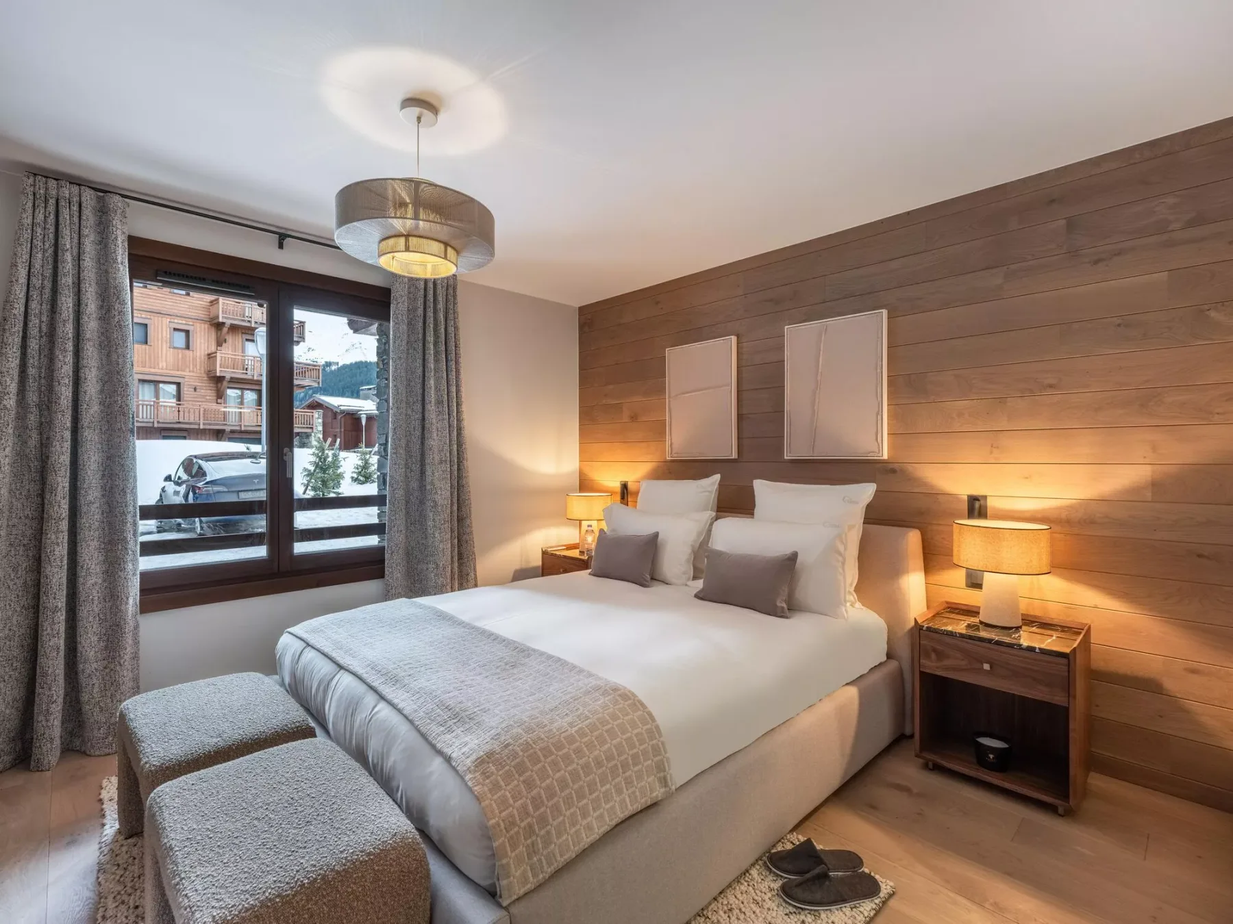 Un dormitorio con una cama bien tendida y una gran ventana con cortinas.
