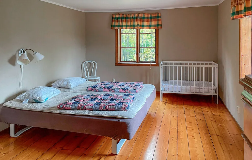 Un dormitorio con una cama, una ventana y una cuna.