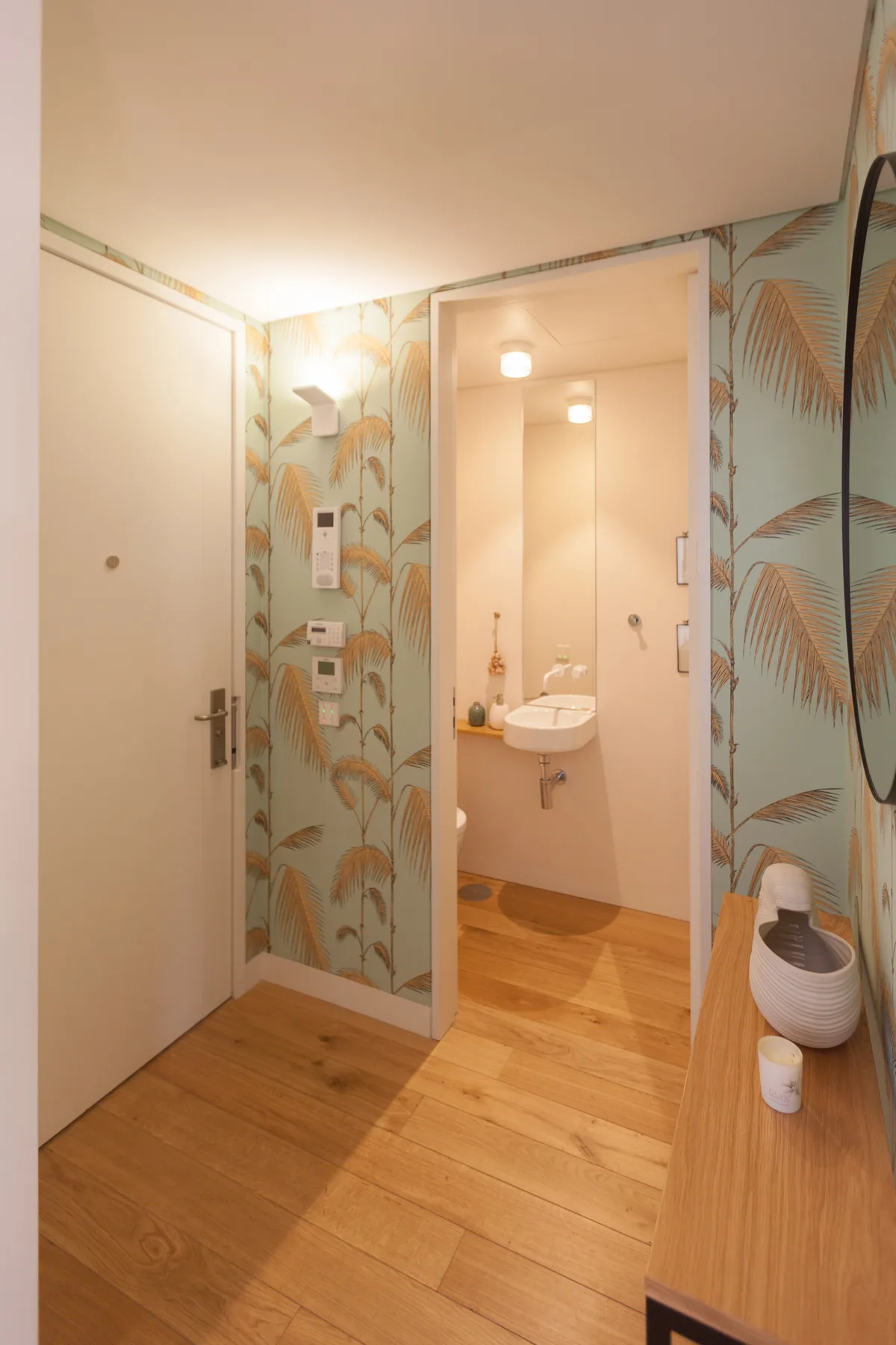 A patterned hallway opens onto a bathroom with a sink.