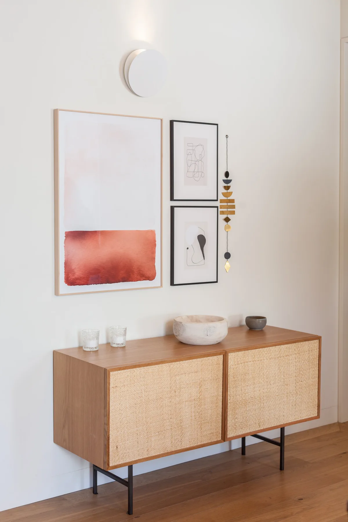 A hallway console stands beneath framed wall art and a small wall decoration.