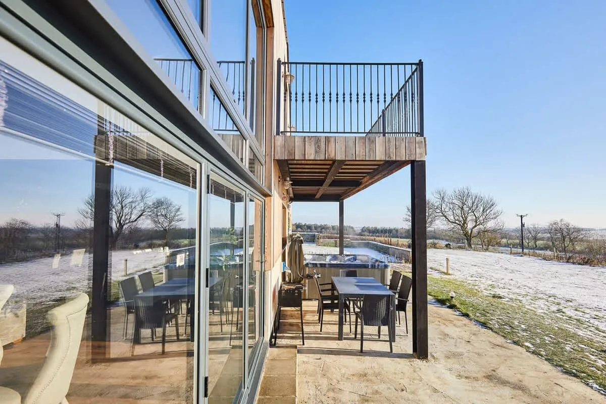 A patio with outdoor seating beside a glass-walled building.