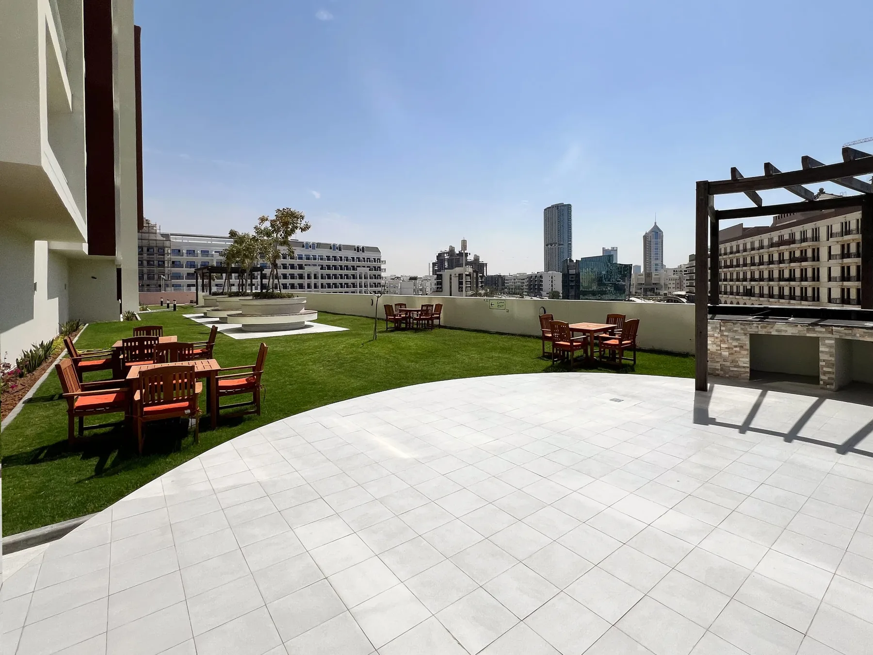 A rooftop terrace with outdoor seating and a city skyline in the background.