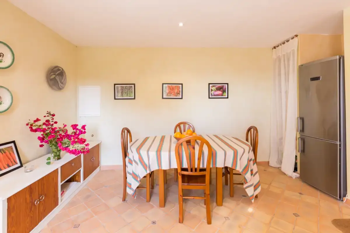 Un comedor con un mantel a rayas y sillas de madera.