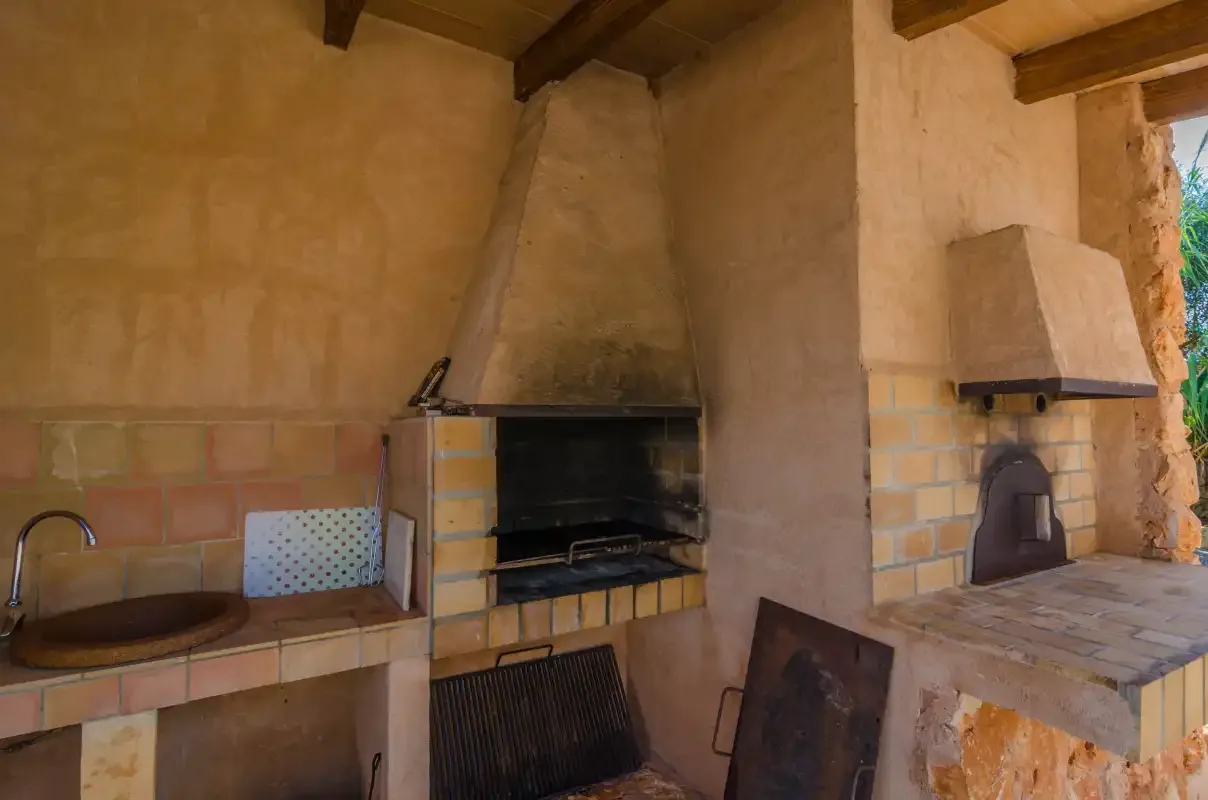 Una zona de cocina al aire libre con parrillas empotradas y un fregadero.