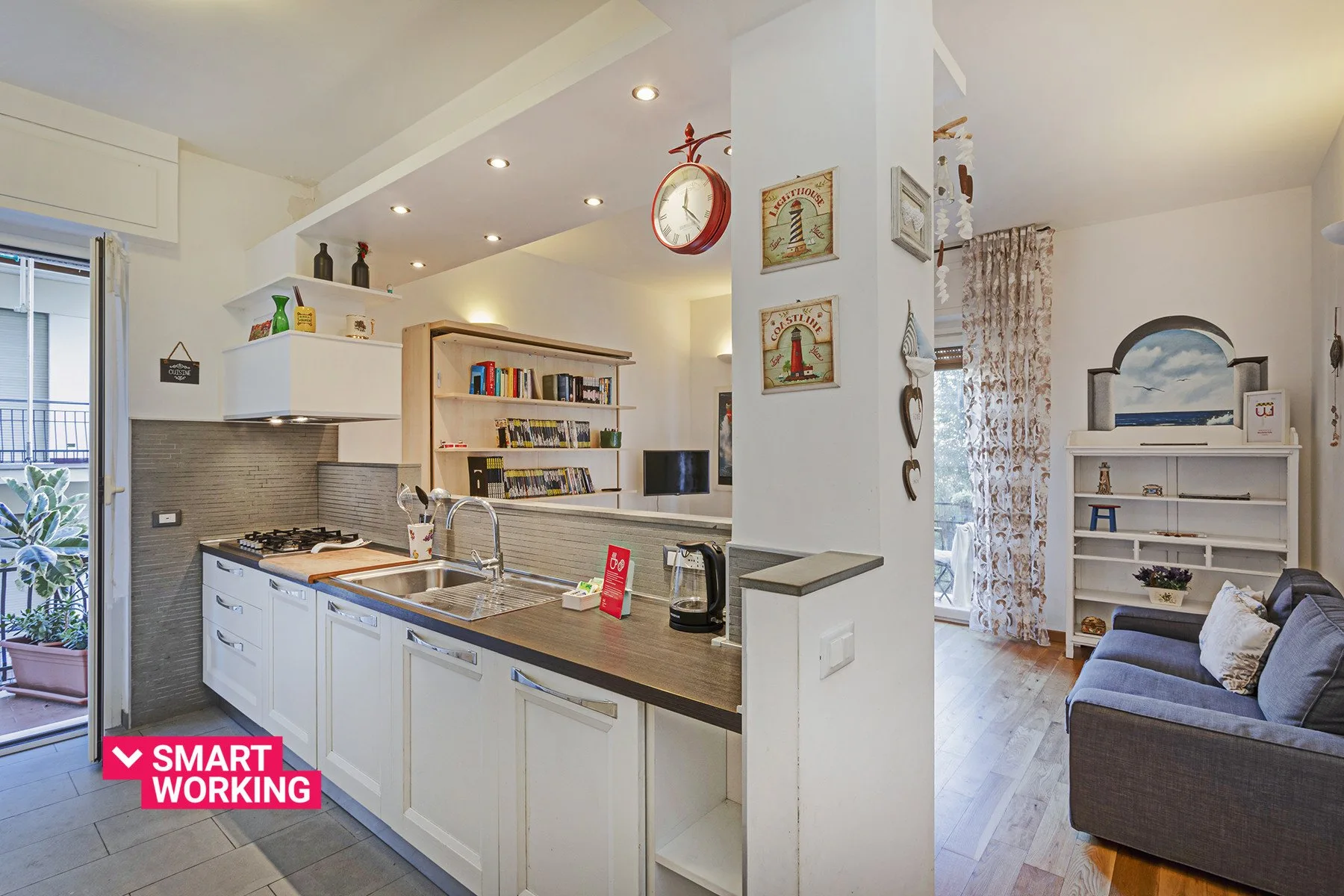 Cocina y sala de estar de planta abierta, con una barra y estanterías.