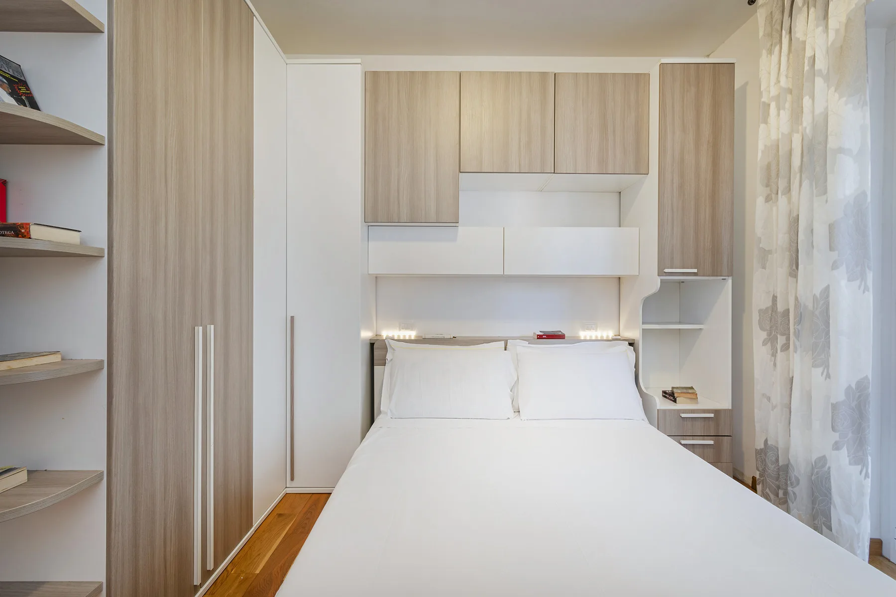 Un dormitorio luminoso con una cama bien hecha y armarios empotrados.