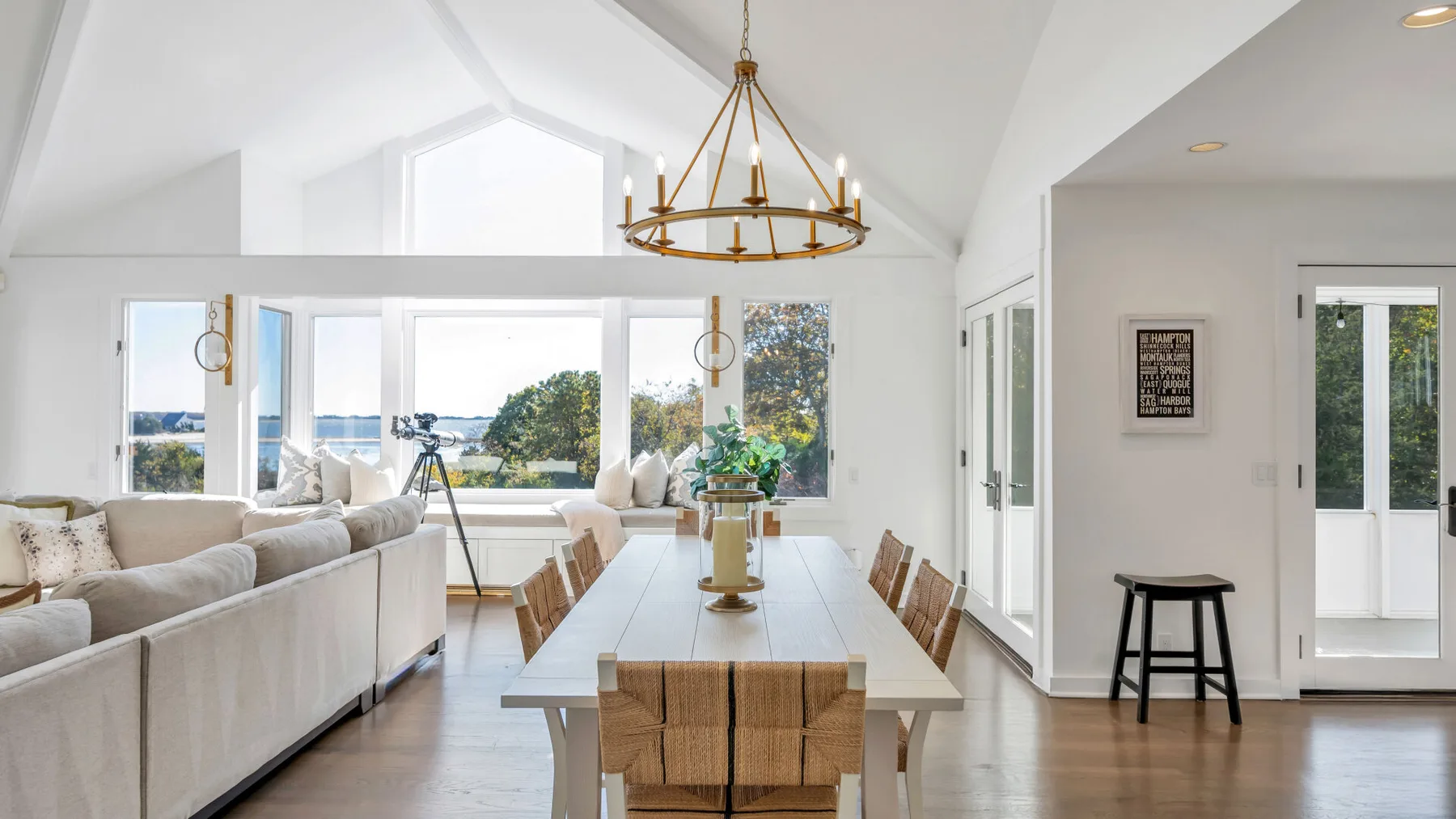 Una luminosa sala-comedor diáfana con grandes ventanas que dan al agua.