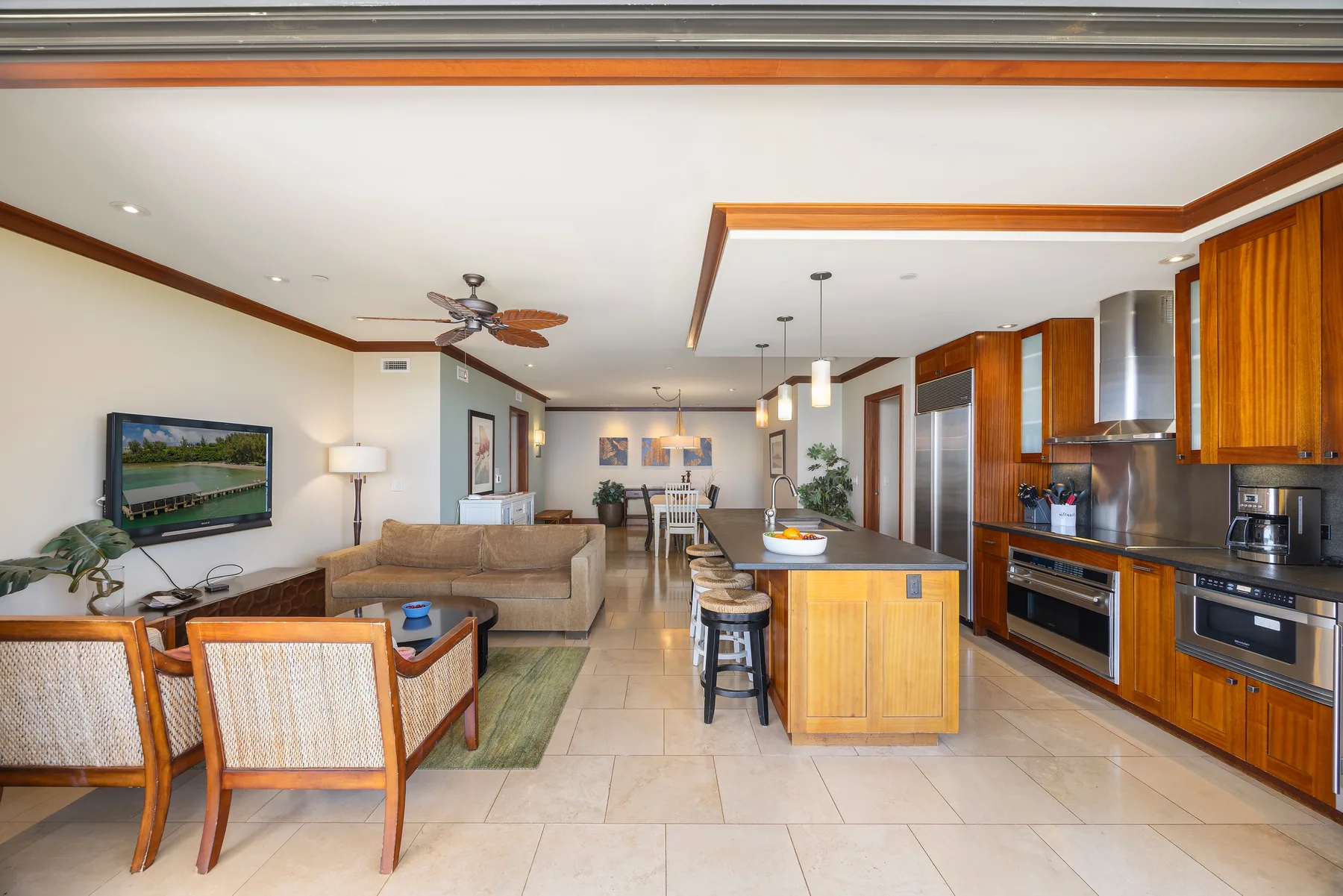 Sala de estar y cocina de concepto abierto, con una isla central y comedor.