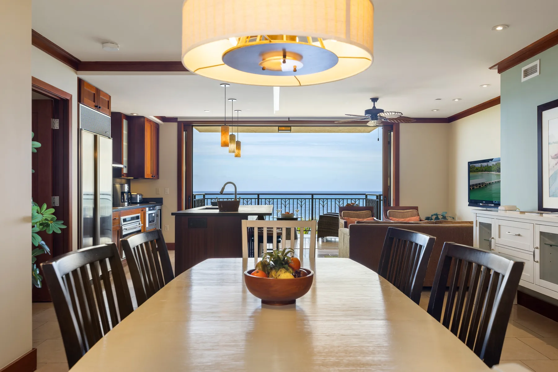 Un comedor con una mesa larga y vistas al mar a través del espacio abierto.