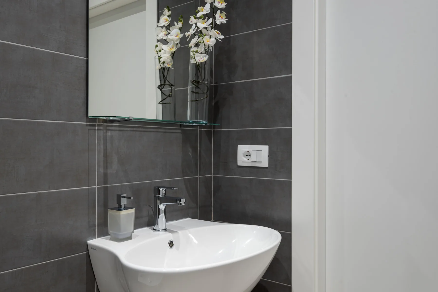 A bathroom vanity with a white sink beneath a mirror.