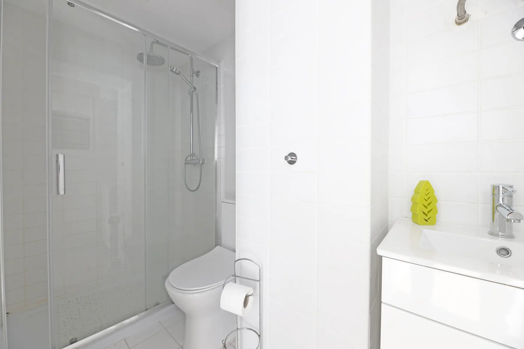 A bright bathroom with a shower, toilet, and sink.