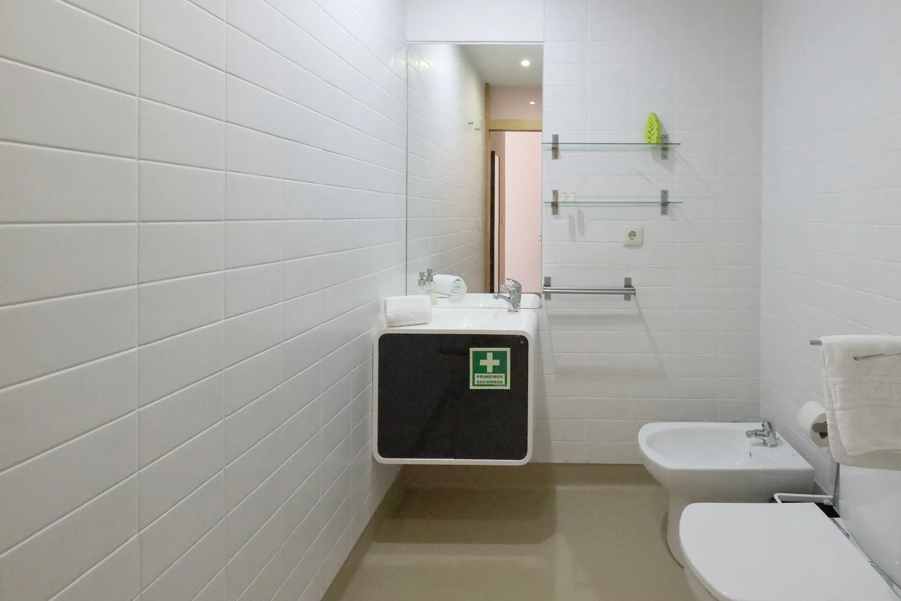 A tiled bathroom with a sink, bidet, and toilet.