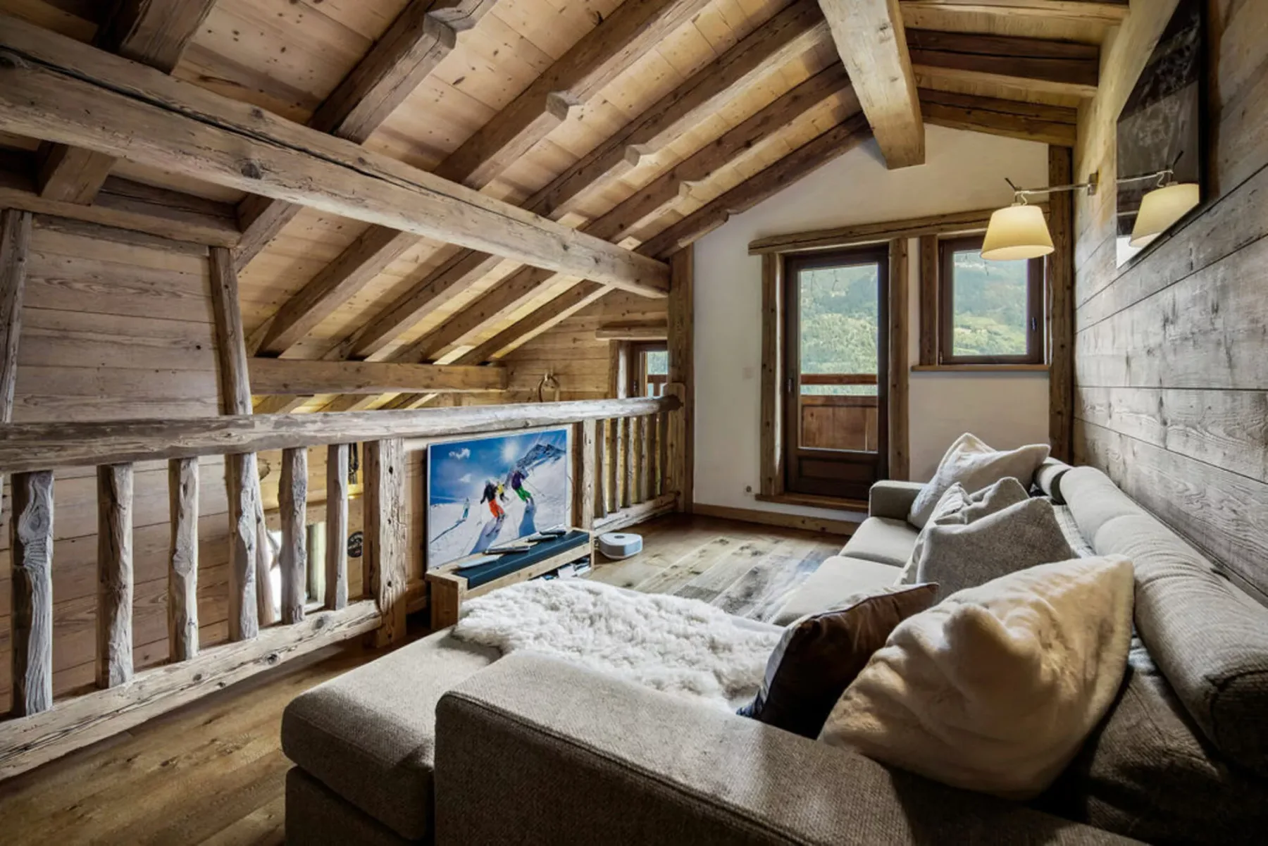 A cozy living area with seating beneath a sloped wooden ceiling.