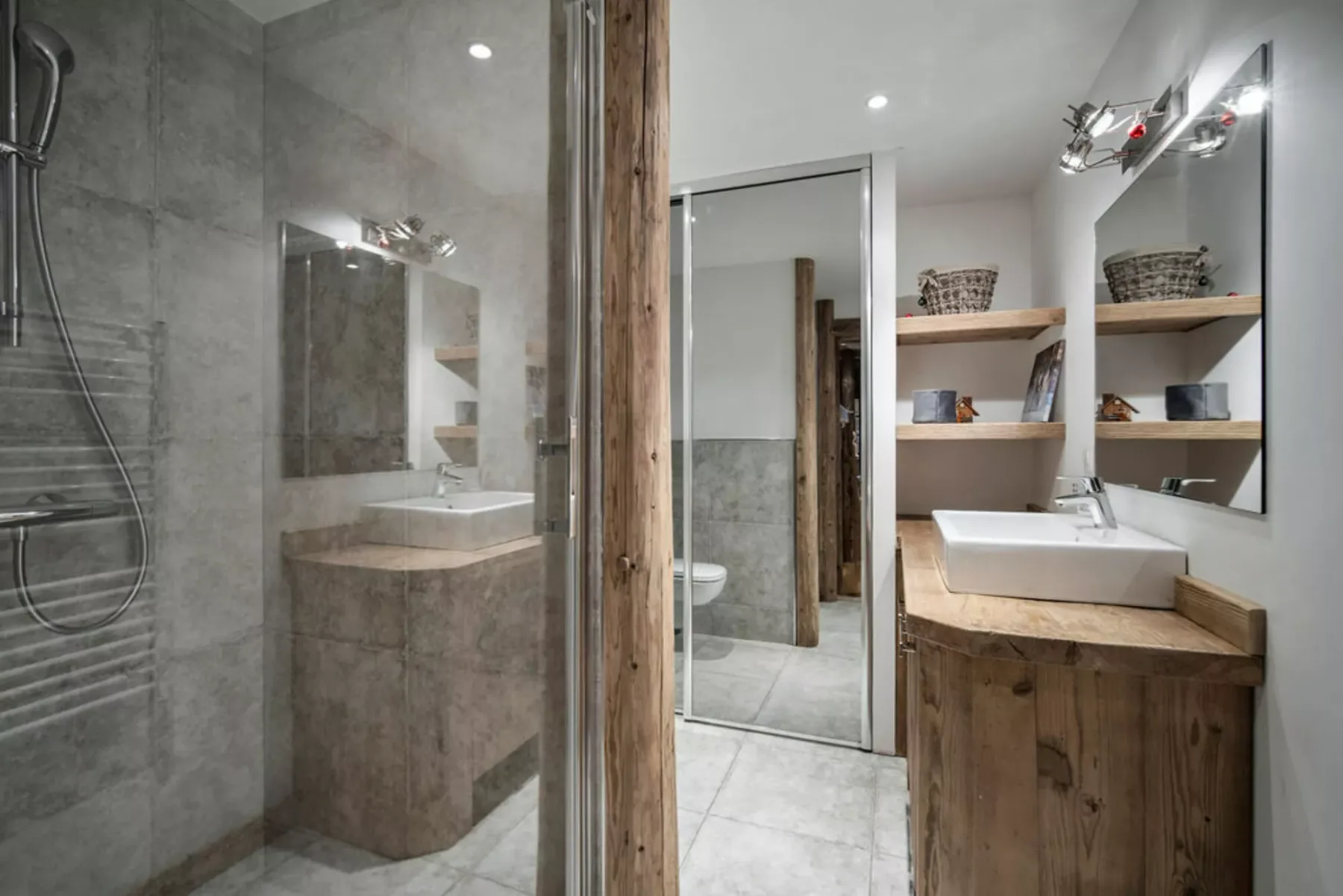 A modern bathroom with a sink vanity, mirror, and glass shower.