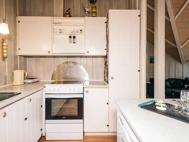 A compact kitchen with white cabinets, an oven, and a countertop.