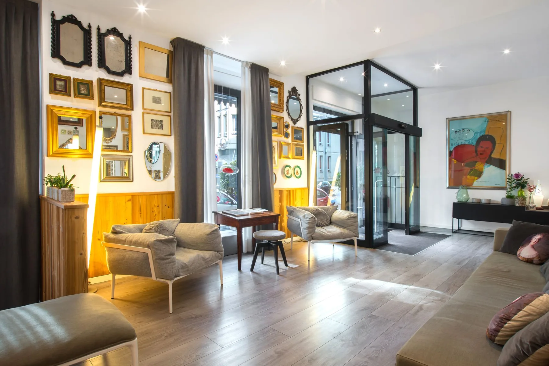 Hotel lobby with seating, artwork, and a revolving-door entrance.