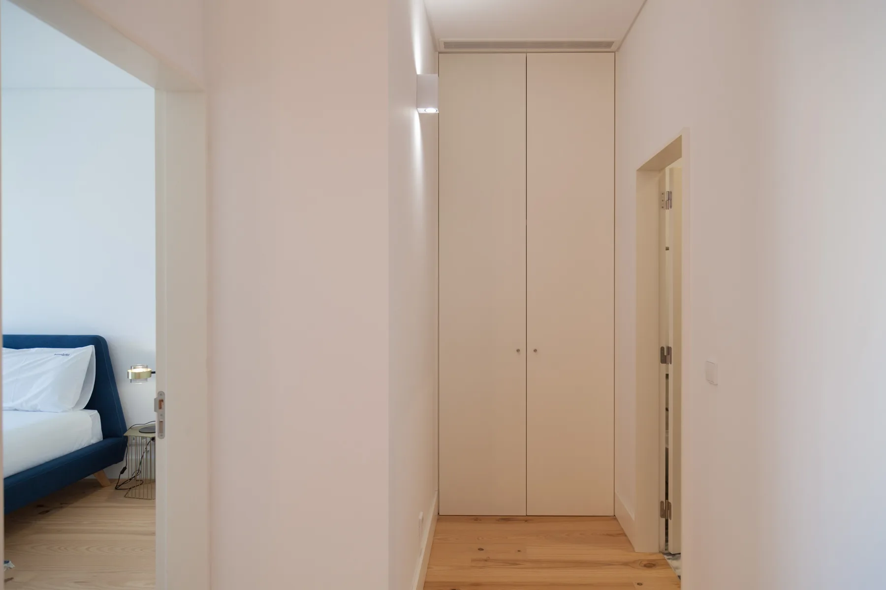 A bedroom is visible through the doorway beside a hallway closet.