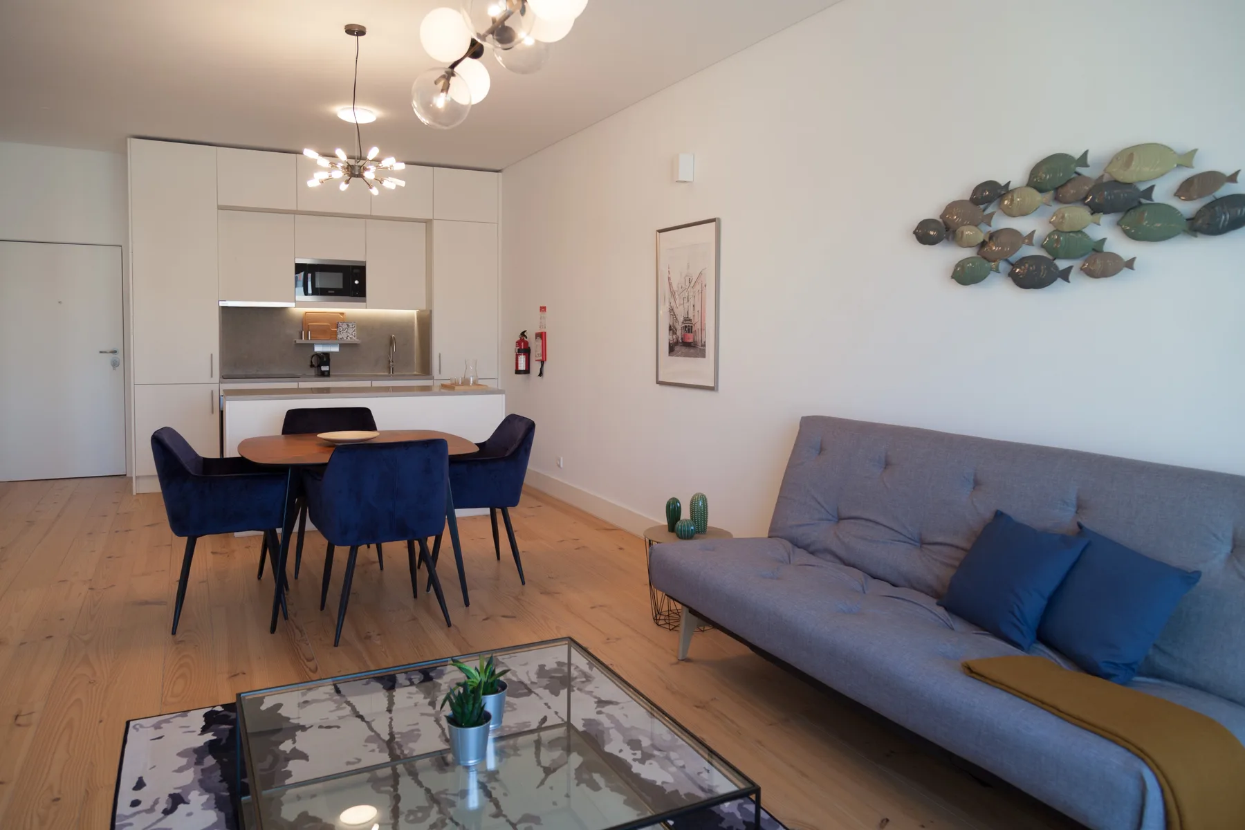 A living and dining area with a gray sofa and a blue dining set.