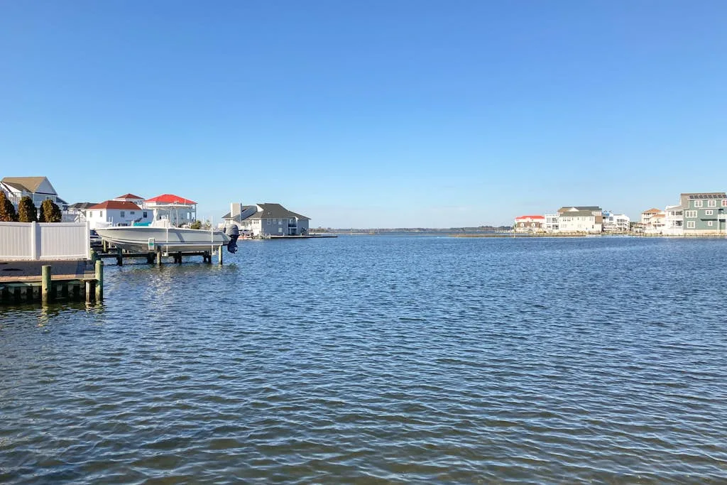 A waterfront scene shows homes and docks along a calm blue inlet.