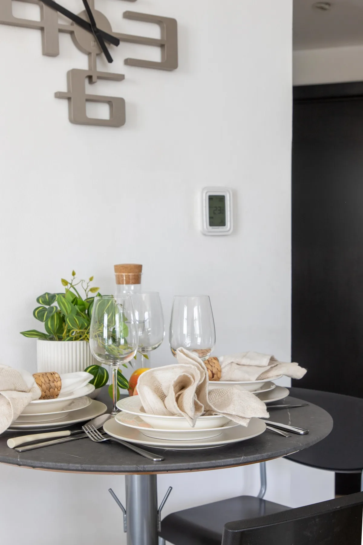 A set dining table with plates, glasses, and folded napkins.