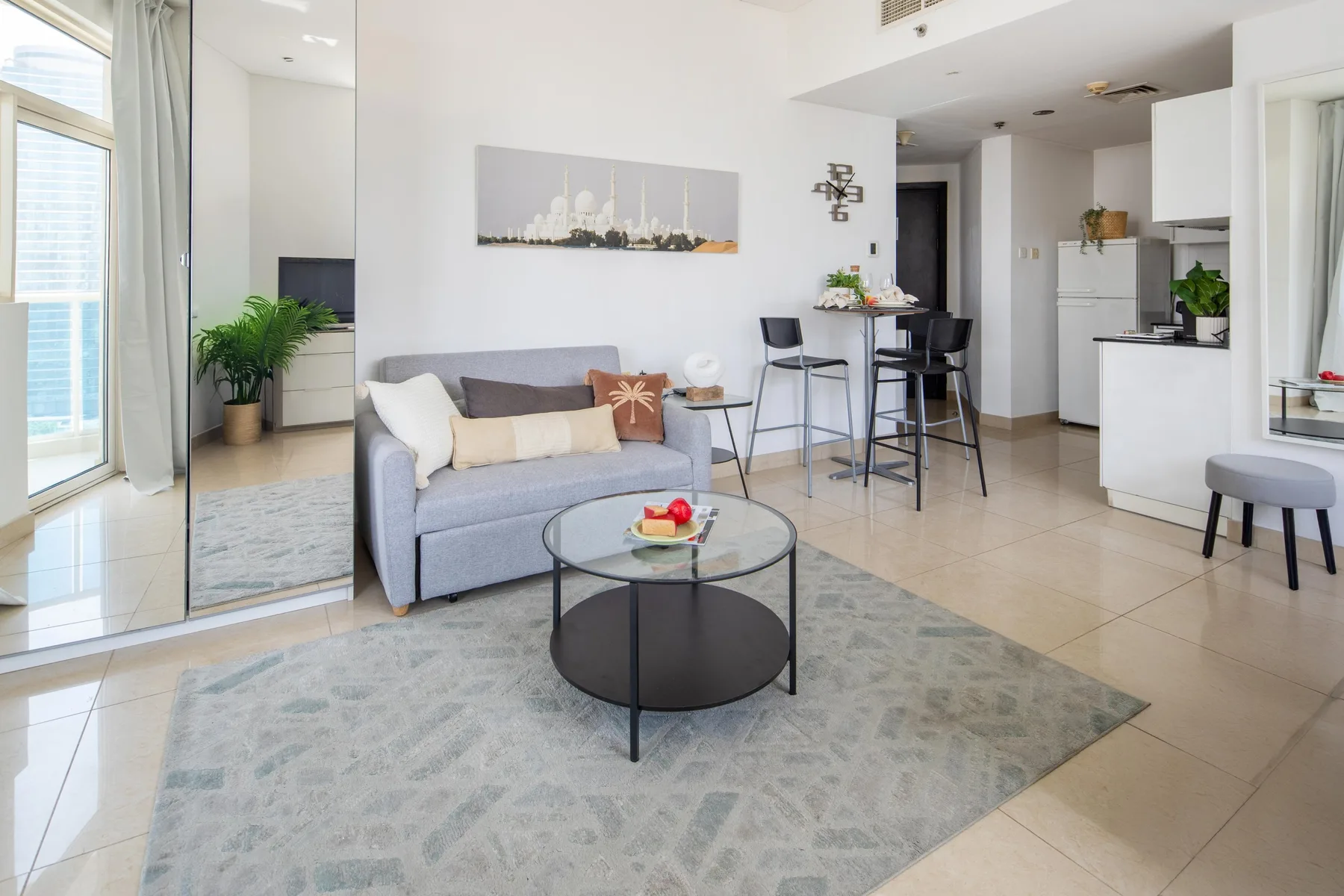 A bright living room with seating, a coffee table, and an open kitchen.